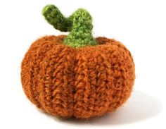 an orange knitted pumpkin with a green top