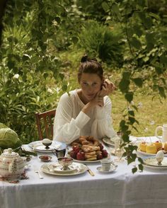 a woman sitting at a table with food on it