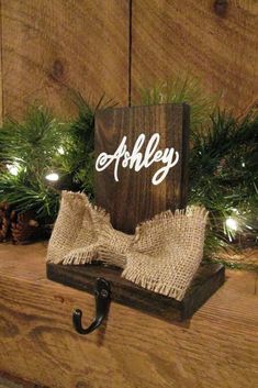 the personalized stocking holder is made from wood and burlocked with rope