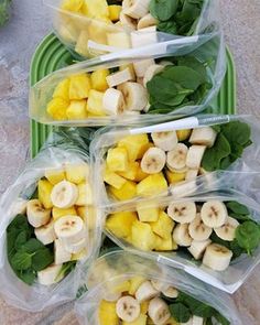 four plastic containers filled with sliced bananas and spinach