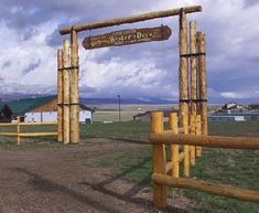 a wooden gate in the middle of a field