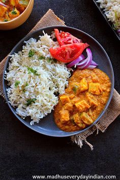 the meal is prepared and ready to be eaten on the table with rice, tomatoes, and chicken