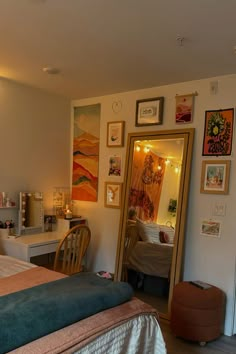 a bed room with a neatly made bed and pictures on the wall