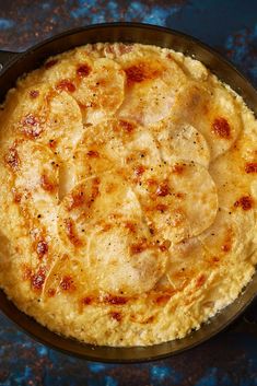 an omelet in a cast iron skillet on a blue surface