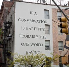 a tall building with a large sign on it's side that says if a conversation is hard, it's probably the one worth having