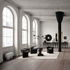 an empty room with large windows and black furniture on the floor in front of it