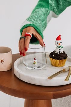 a cupcake on a plate with a snowman figurine next to it