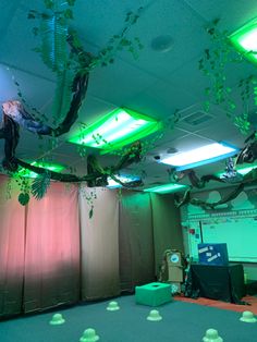 the room is decorated with green lights and plants hanging from the ceiling, along with plastic cups on the floor