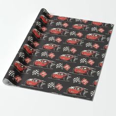 a black wrapping paper with red cars and checkered flags printed on the side,