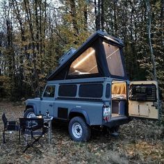 an off - road vehicle is parked in the woods with its door open and lights on