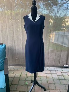 Tasteful navy blue dress with contrasting white collar. Fully lined, back zip. Polyester. In good vintage condition with no rips or stains. The bust measures 18 inches from armpit to armpit laying flat. The waist measures 15 inches across laying flat. 40 inches from shoulder to hem. Polyester. Please examine the pics, feel free to ask questions. Dress With White Collar, Blue Sheath Dress, Navy Blue Dress, Dress Cuts, Navy Blue Dresses, White Collar, Dress Clothes For Women, Blue Dress, Sheath Dress