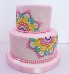 a three tiered cake decorated with colorful designs