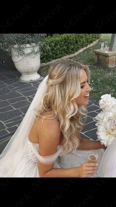 a woman in a wedding dress is holding a bouquet and looking at another woman's face