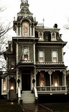 an old victorian house with a clock on the front