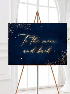 a sign that says to the moon and back in gold lettering on a blue background