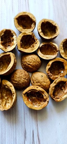 walnuts are sitting on a white table and have been cut open to show the insides