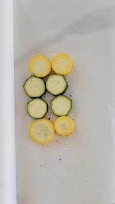 sliced cucumbers and lemons on a cutting board next to a white towel