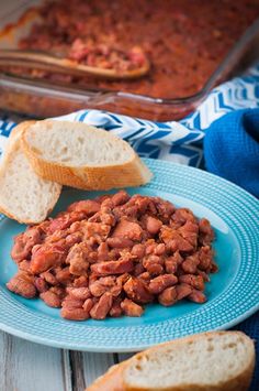 a blue plate topped with beans next to bread