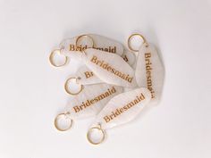 five bridesmaid keychains with the names of their wedding day written on them