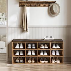 a wooden shoe rack with shoes on it and a hat hanging from the wall above