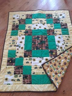 a green and yellow quilt on the floor