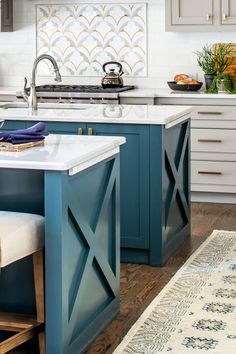 a kitchen with blue cabinets and white counter tops