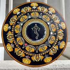 a decorative plate with an omesh symbol painted on it