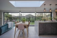 an open kitchen and dining room area with skylights