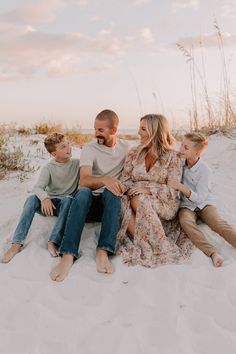 a family sitting on the beach at sunset during their vacation in destinia, florida