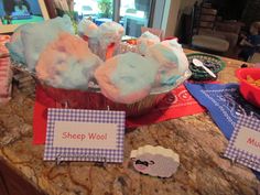 cupcakes with sheep wool on them sitting on a counter