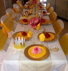 a table set with yellow and pink plates, napkins and flowers on it for a princess party