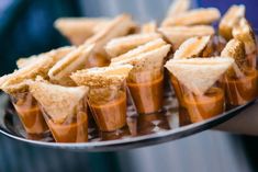 there are many small cups that have food in them on the tray and someone is holding one