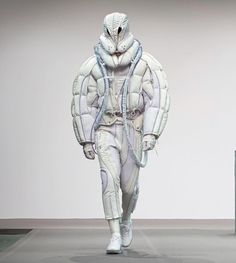 a man is walking down the runway in an all - white outfit with futuristic features