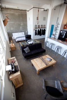 a living room filled with furniture next to a kitchen