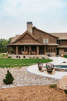 a large house with a pool in the front yard and two chairs on the patio