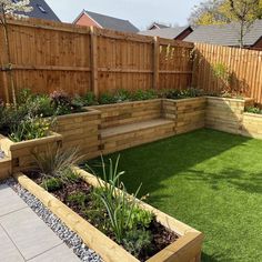 a garden with grass and wooden planters in the middle, surrounded by wood fence