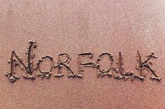 the word norfolk written in sand on a beach