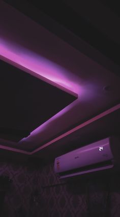 an air conditioner in the middle of a room with purple lighting on it's ceiling