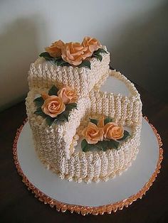 a three tiered cake decorated with flowers on a white plate and brown tablecloth