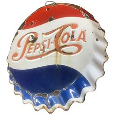 an old pepsi bottle cap with the word pepsi cola painted on it