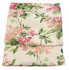 two sheets with pink and green flowers on them, one is folded over the other