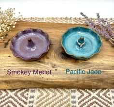 two small bowls sitting next to each other on a wooden board with the words smokey melot and pacific jade