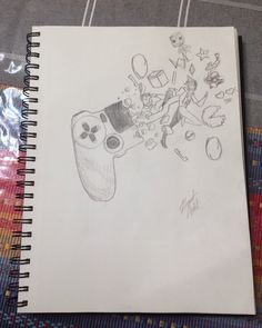 a drawing of a video game controller being drawn on a piece of paper with other items in the background