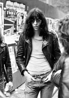 black and white photograph of two women standing next to each other with their hands in their pockets