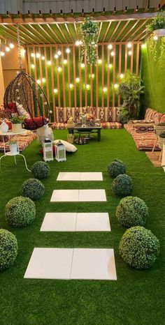 an outdoor seating area with grass and white stepping stones