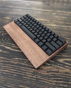 a computer keyboard sitting on top of a wooden table