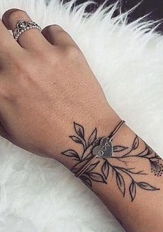 a woman's hand with a flower tattoo on it