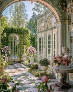 an archway leading into a garden filled with flowers