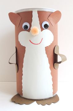 a brown and white paper cup with an animal face on it's side, sitting in front of a white wall