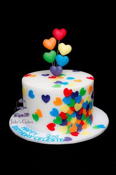 a birthday cake decorated with hearts and balloons